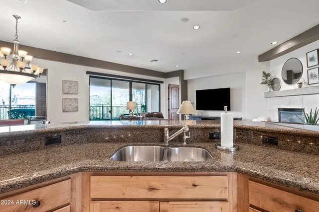 a dining room with wooden floor a chandelier a wooden table and chairs