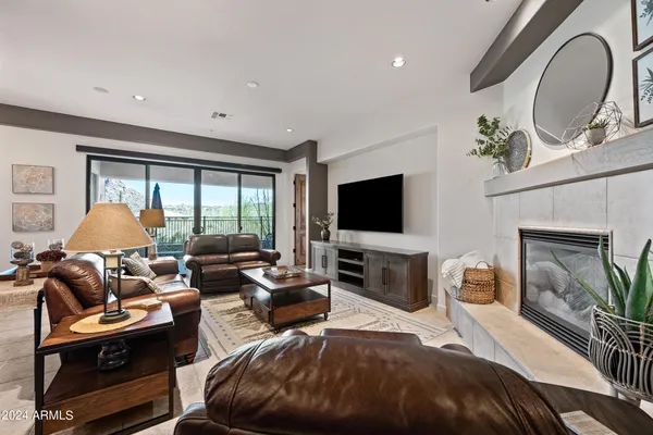 a bedroom with furniture a flat screen tv and a fireplace