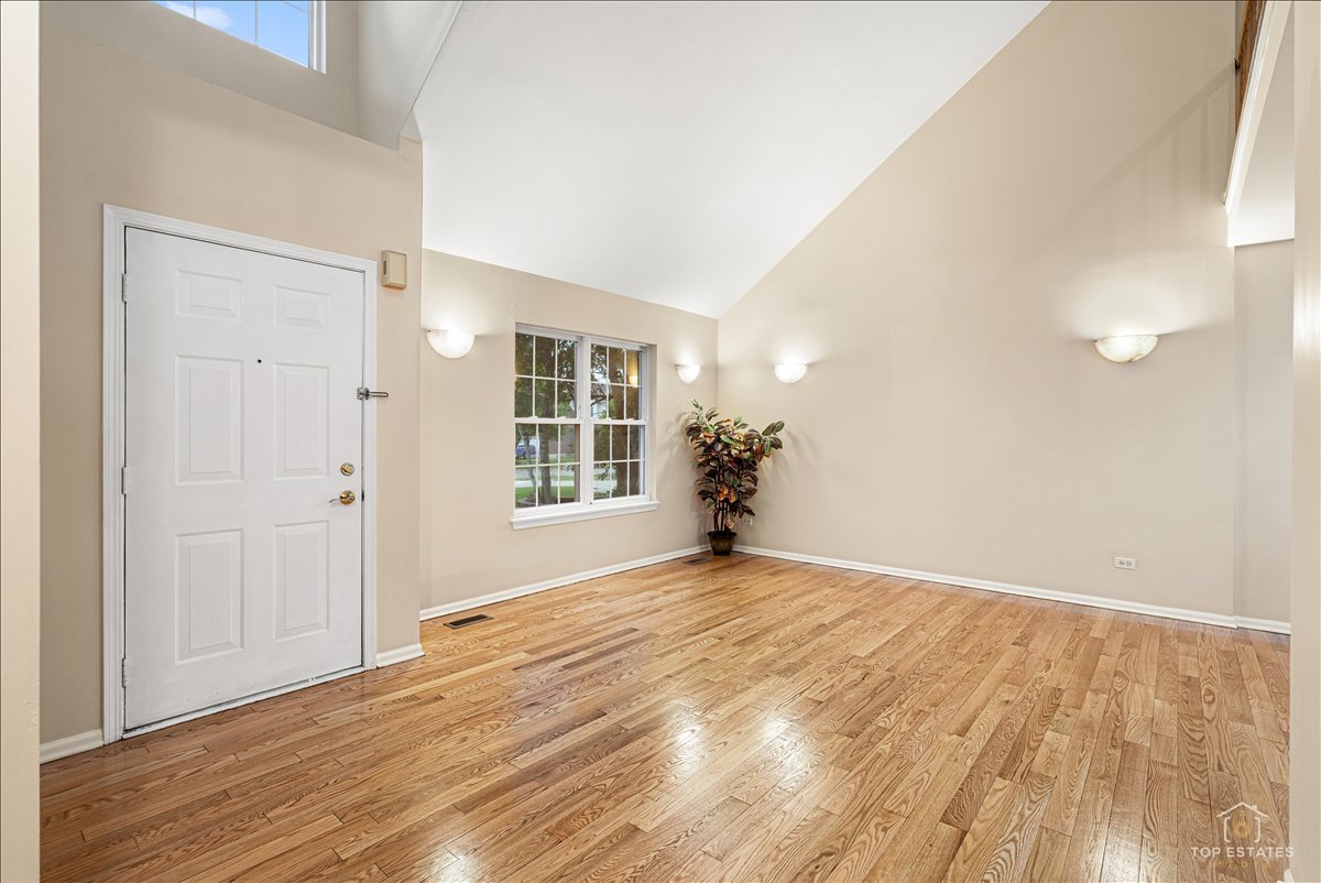 7 Eagle Court Streamwood, IL 60107 - Photo 3 of 31 a view of an empty room with wooden floor and a window