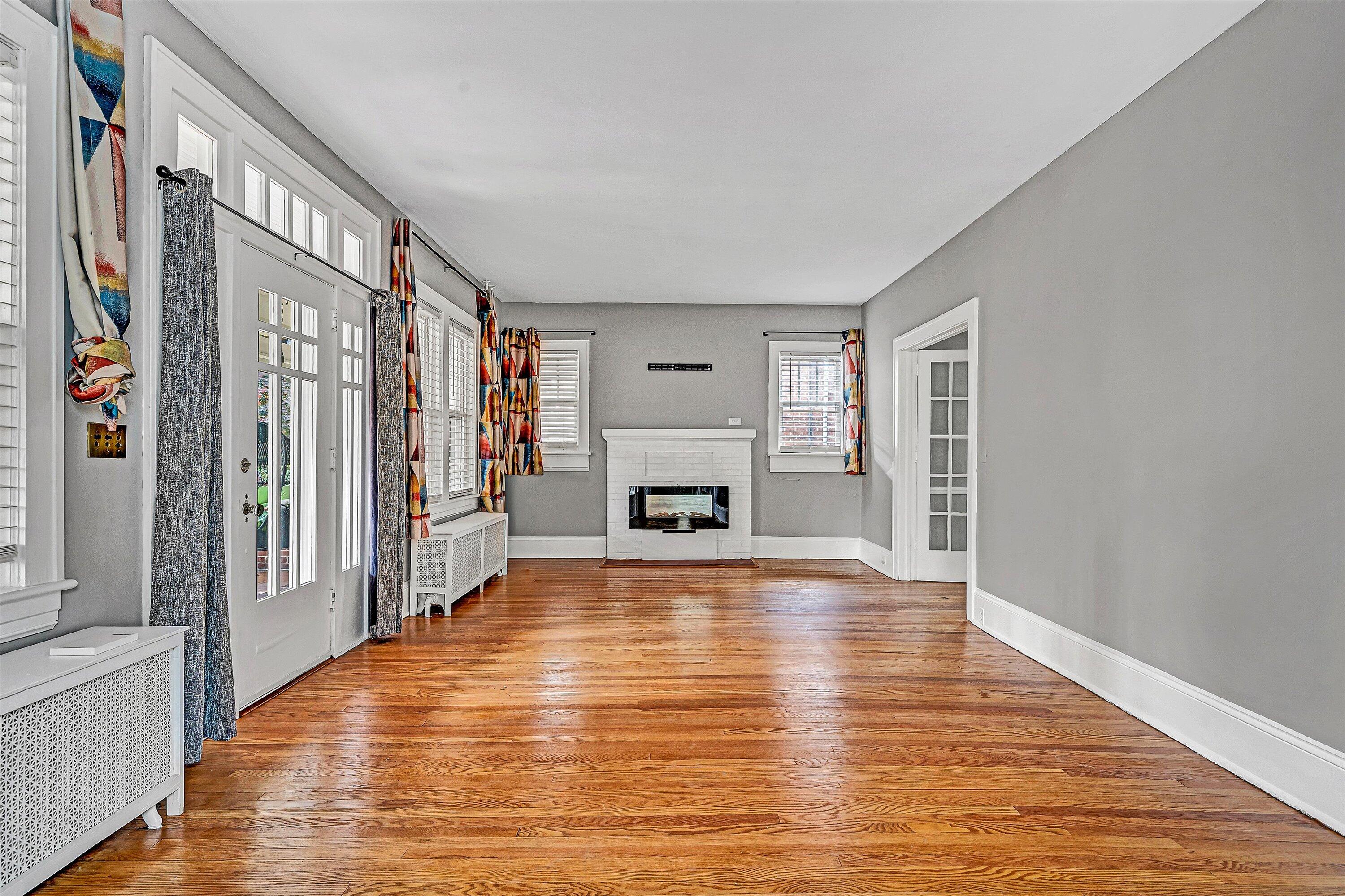 1725 Arlington Road Southwest Roanoke, VA 24015 - Photo 5 of 44 a view of an empty room with wooden floor fireplace and a window
