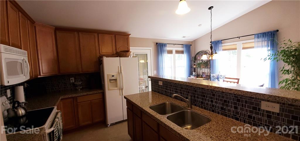 11647 Tucker Field Road Midland, NC 28107 - Photo 11 of 30 a kitchen with a sink a refrigerator and cabinets