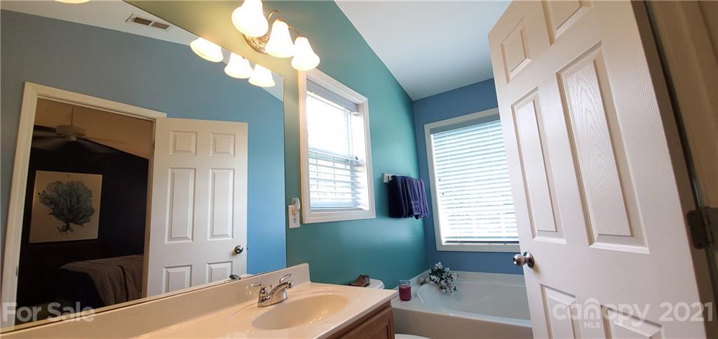 11647 Tucker Field Road Midland, NC 28107 - Photo 16 of 30 a bathroom with a bathtub a sink and a large mirror