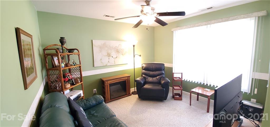 11647 Tucker Field Road Midland, NC 28107 - Photo 20 of 30 a living room with furniture a fireplace and a flat screen tv