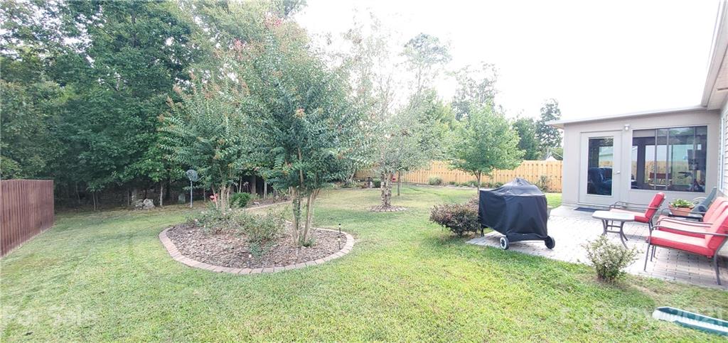 11647 Tucker Field Road Midland, NC 28107 - Photo 26 of 30 a view of a backyard with table and chairs potted plants and large tree