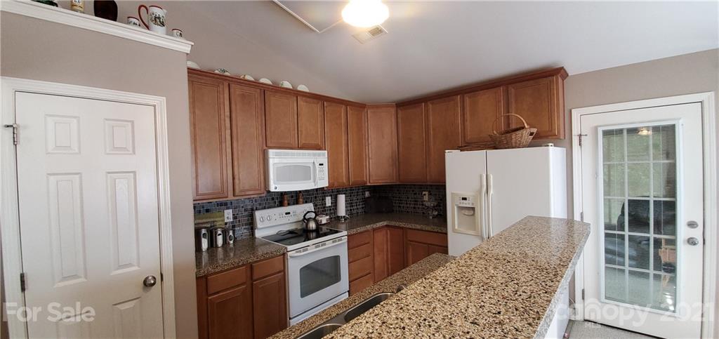 11647 Tucker Field Road Midland, NC 28107 - Photo 8 of 30 a kitchen with a refrigerator and a stove top oven