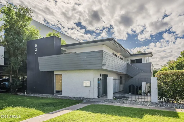 a front view of a house with a yard garage and outdoor seating