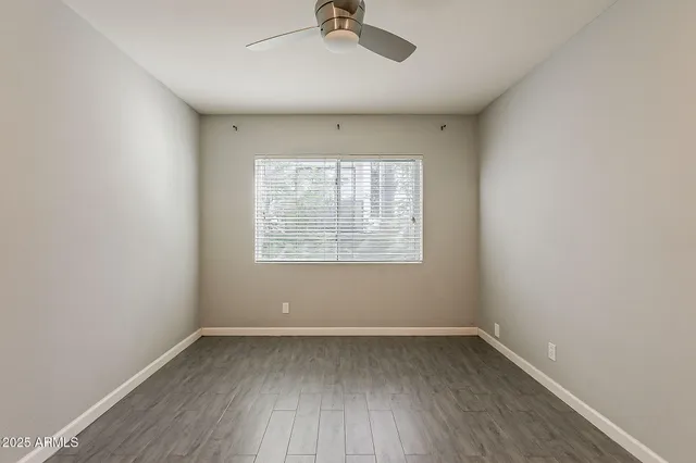 an empty room with a window and wooden floor