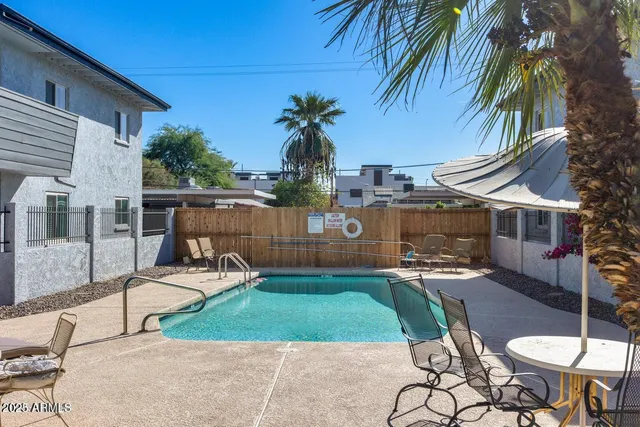 a view of a chair and table in backyard of the house