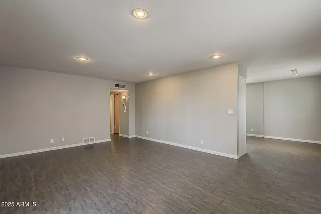 an empty room with wooden floor and door