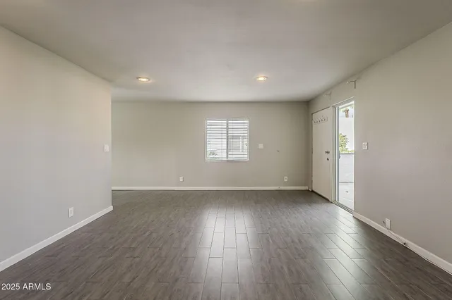 an empty room with wooden floor and window