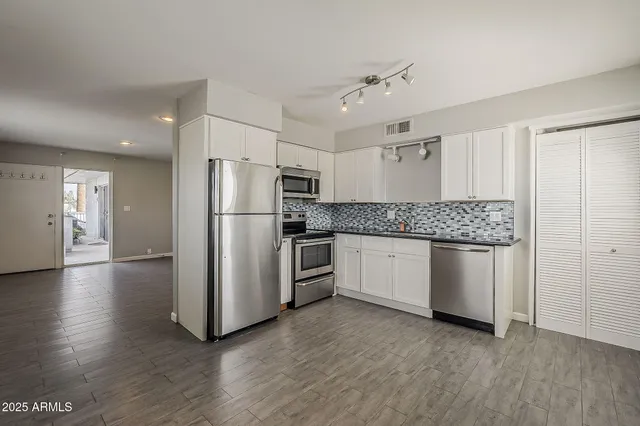 a kitchen with stainless steel appliances granite countertop a refrigerator and a stove top oven
