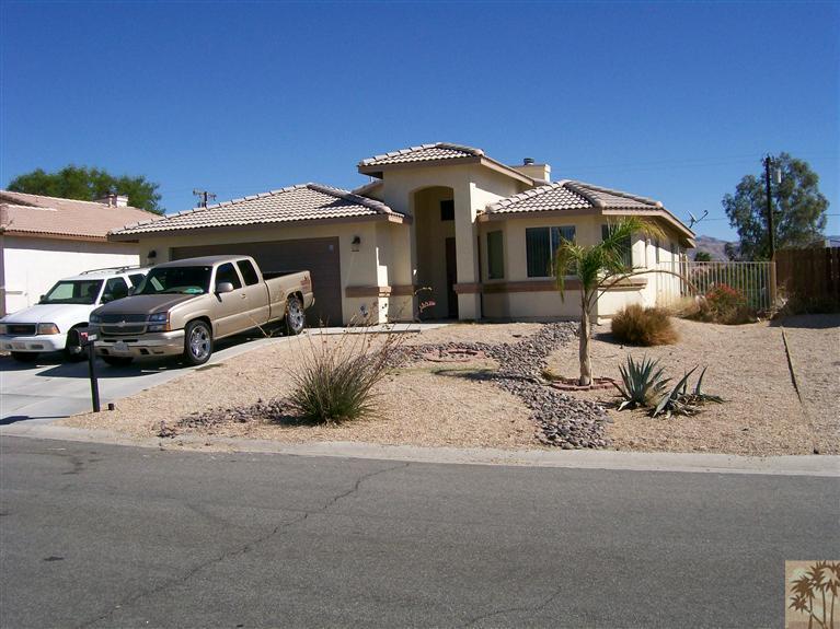 13700 El Rio Lane Desert Hot Springs, CA 92240 - Photo 1 of 9 a front view of a house with a yard
