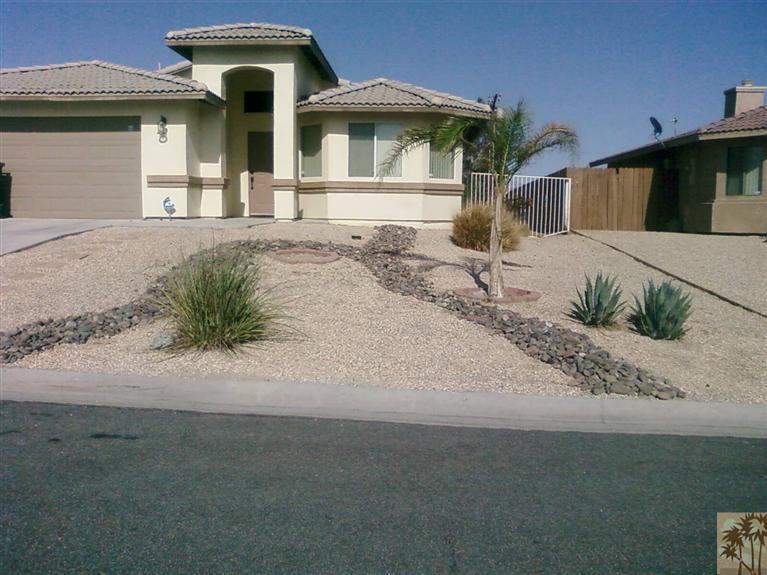 13700 El Rio Lane Desert Hot Springs, CA 92240 - Photo 2 of 9 a front view of a house with garden