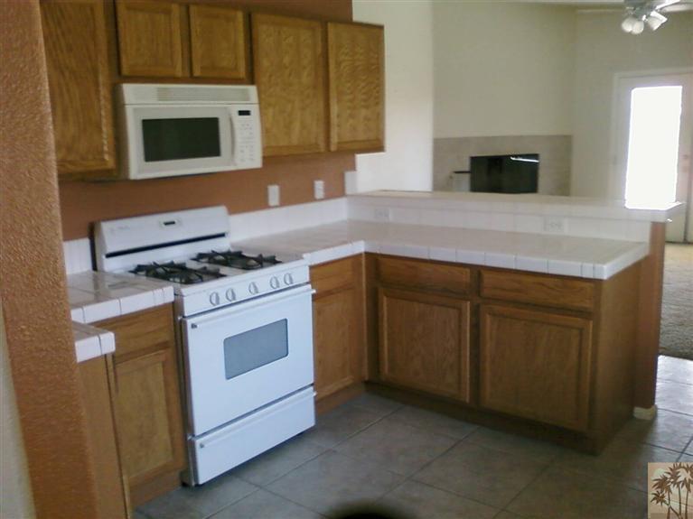 13700 El Rio Lane Desert Hot Springs, CA 92240 - Photo 3 of 9 a kitchen with a stove and a microwave