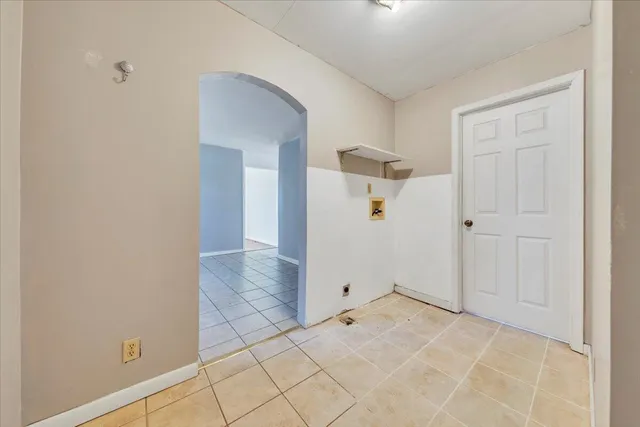 an empty room with an entryway and closet