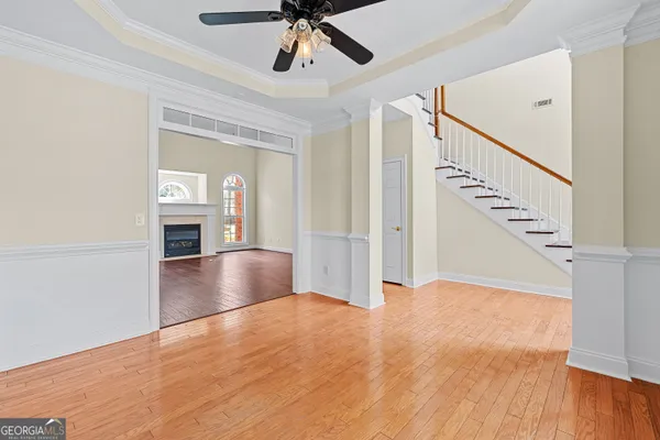 a view of an empty room with wooden floor fireplace and a window