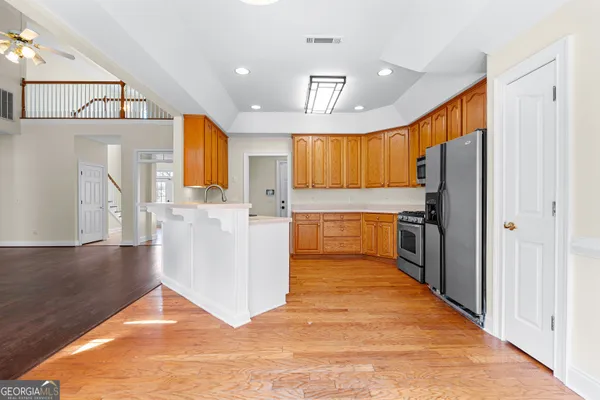 a kitchen with granite countertop wooden cabinets stainless steel appliances and a window