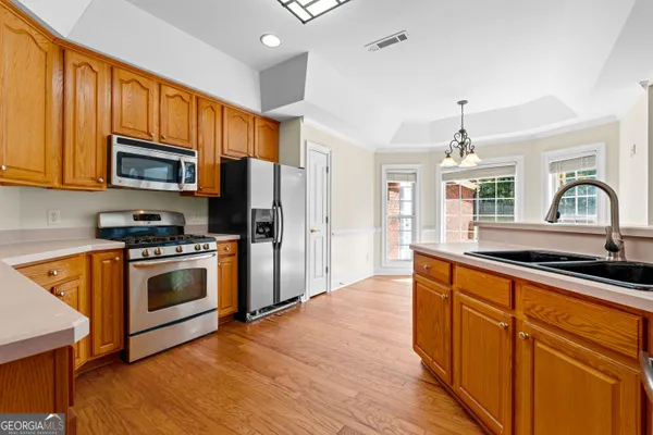 a view of a hallway with wooden floor and a bathroom