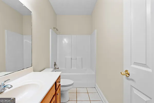 a view of an empty room with window and chandelier fan