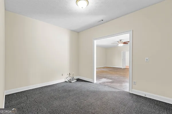 an empty room with a window and ceiling fan