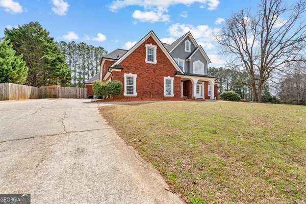 a front view of house with yard and trees around