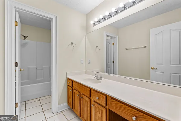 an empty room with wooden floor ceiling fan and windows