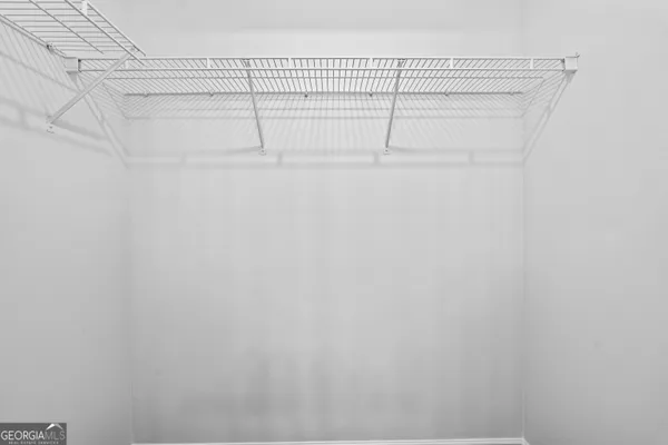 a view of a room with wooden floor and ceiling fan