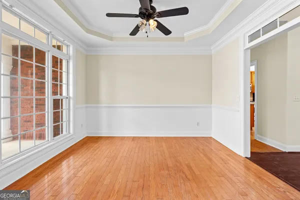 a view of an empty room with a window and wooden floor