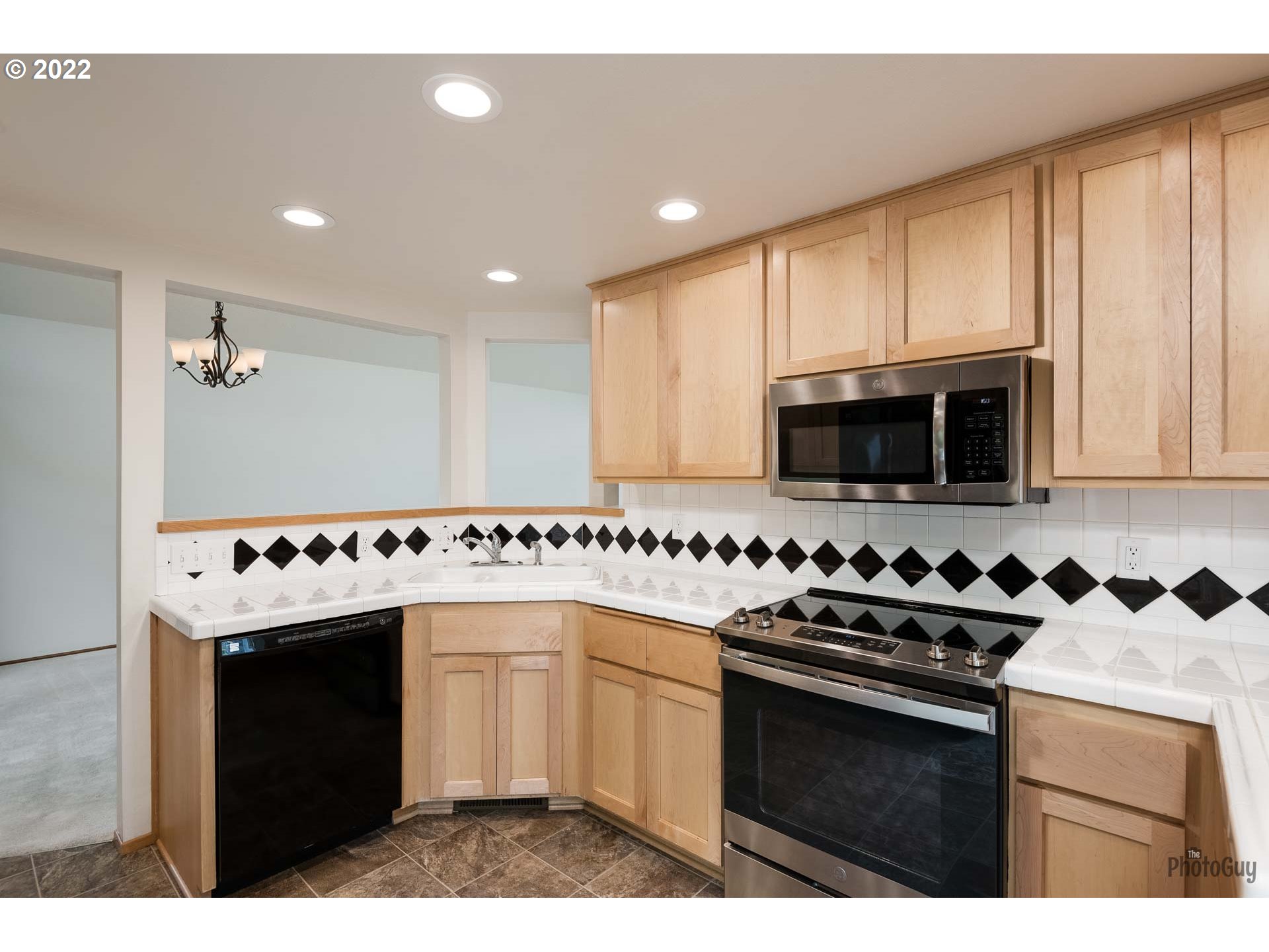589 Granite Place Springfield, OR 97477 - Photo 6 of 31 a kitchen with stainless steel appliances granite countertop a stove a sink and a microwave
