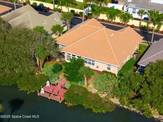 an aerial view of a house with an outdoor space and seating area