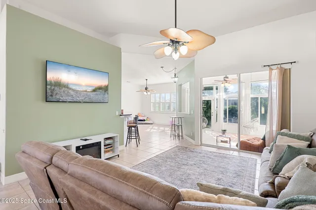 a living room with furniture a chandelier and a large window