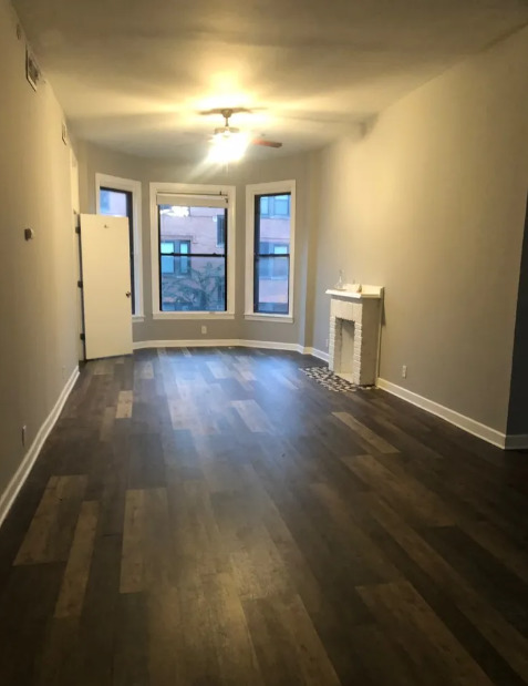 2950 North Sheffield Avenue, Unit 2F Chicago, IL 60657 - Photo 2 of 7 an empty room with wooden floor and window