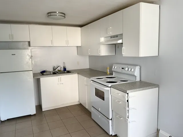 a kitchen with a stove top oven and white cabinets