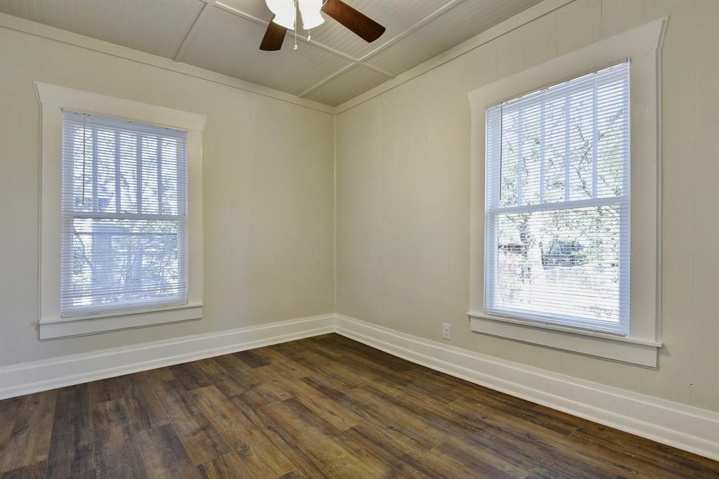 1115 South Rusk Avenue Denison, TX 75020 - Photo 11 of 21 an empty room with wooden floor and windows