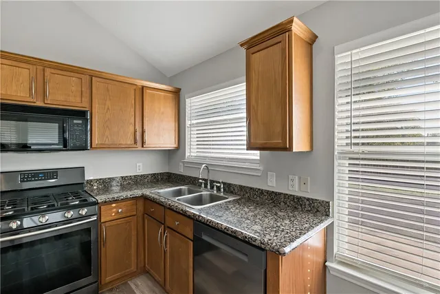 a kitchen with stainless steel appliances granite countertop a sink stove and microwave