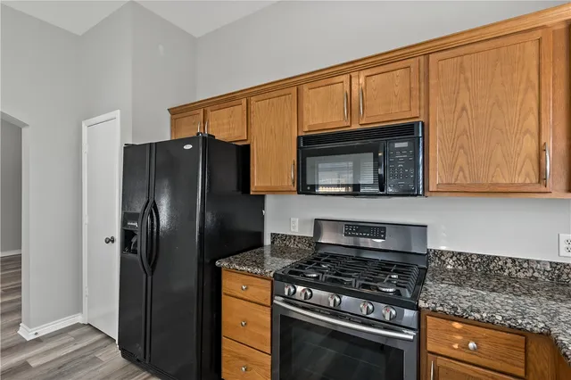a kitchen with stainless steel appliances granite countertop a stove microwave and refrigerator