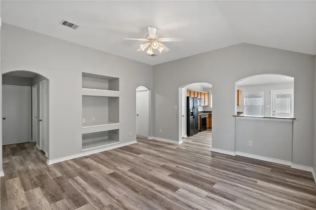 a view of a hallway with wooden floor and chandelier