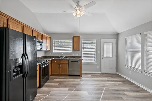 a kitchen with stainless steel appliances granite countertop a refrigerator stove and sink
