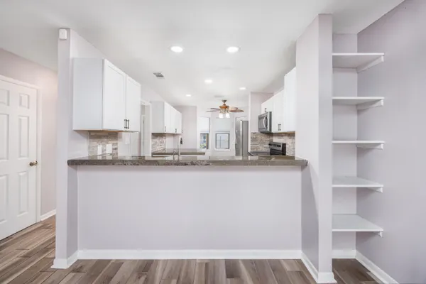 a view of a kitchen with cabinets and wooden floor