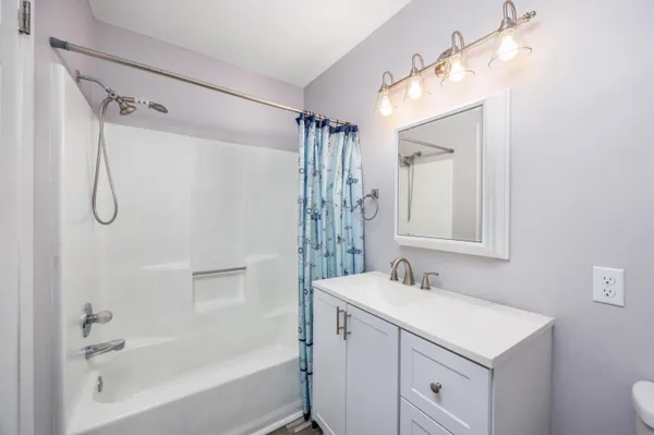 a bathroom with a shower a sink and a mirror