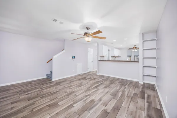 a view of a kitchen with wooden floor and a ceiling fan