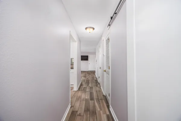 a view of a hallway with wooden floor and staircase