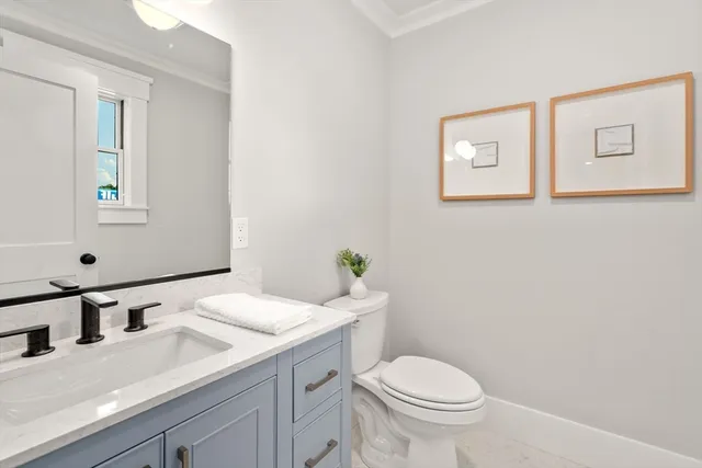 a bathroom with a granite countertop toilet sink and mirror