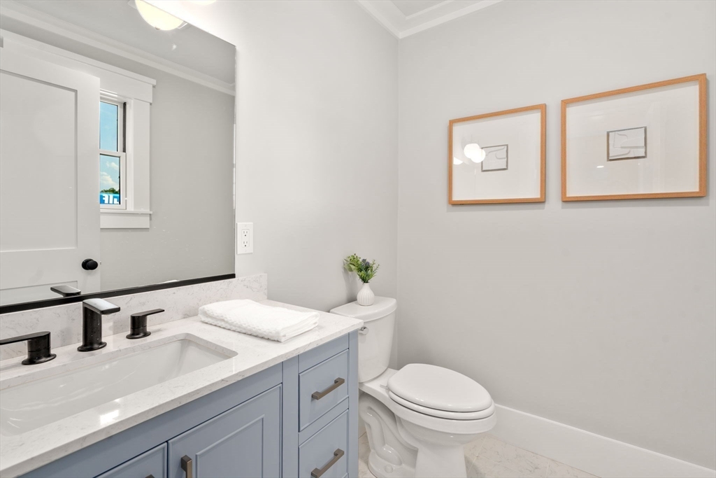 11 Macarthur Street, Unit A Somerville, MA 02145 - Photo 16 of 35 a bathroom with a granite countertop toilet sink and mirror