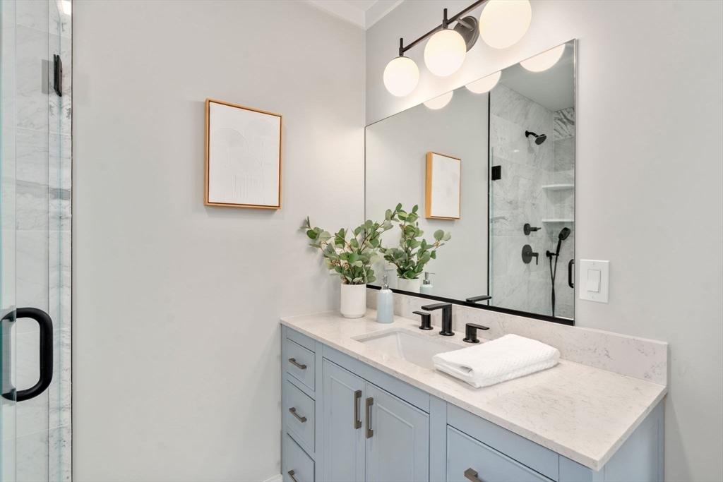 11 Macarthur Street, Unit A Somerville, MA 02145 - Photo 19 of 35 a bathroom with a sink vanity granite and a mirror