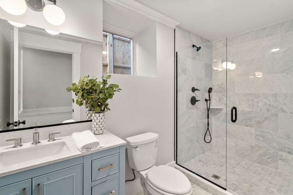 11 Macarthur Street, Unit A Somerville, MA 02145 - Photo 24 of 35 a bathroom with a granite countertop sink a toilet and shower