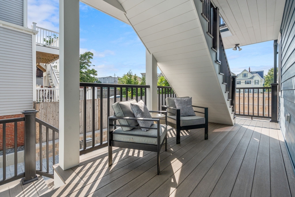 11 Macarthur Street, Unit A Somerville, MA 02145 - Photo 28 of 35 a balcony with wooden floor table and chairs