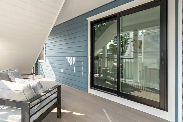 a room with a balcony a bed and glass door