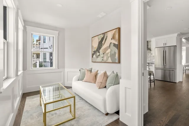 a living room with furniture a large window and wooden floor