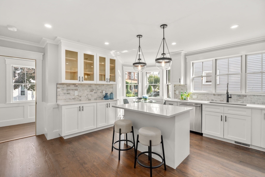 11 Macarthur Street, Unit A Somerville, MA 02145 - Photo 9 of 35 a kitchen with white cabinets and wooden floor
